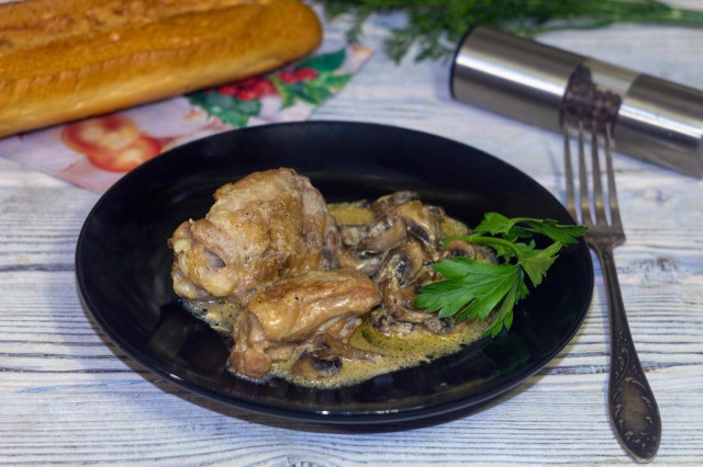 Chicken pieces with champignons and paprika in a frying pan