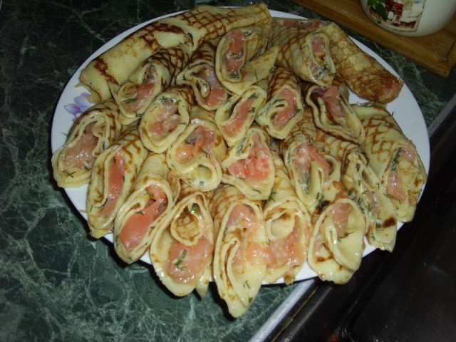 Rolls of pancakes with salmon