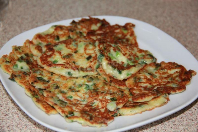 Pancakes with green onions and cheese on sour cream