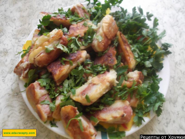 Sausages in batter with parsley in a frying pan