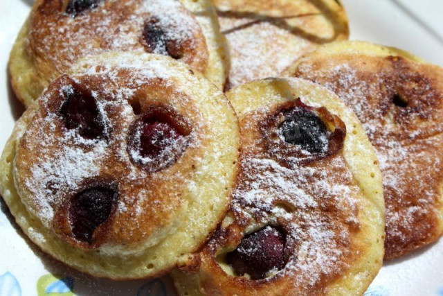 Fluffy pancakes with cherries in milk