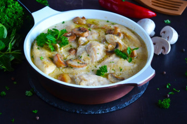 Chicken with mushrooms in sour cream sauce in a frying pan
