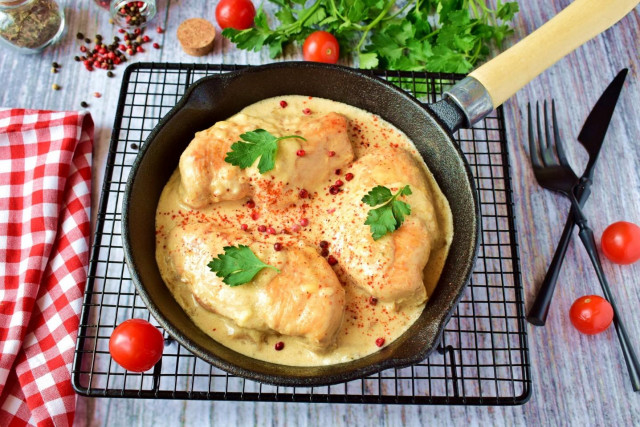 Chicken in cream sauce with cheese in a frying pan