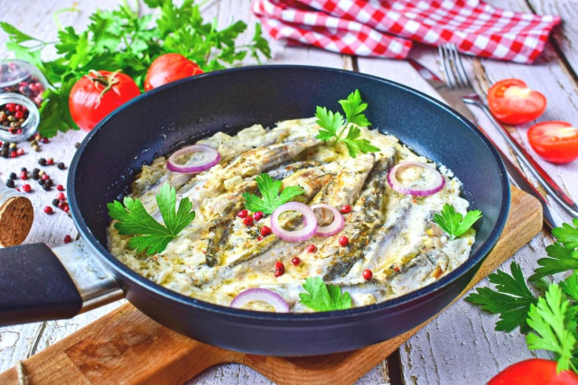 Capelin stewed with onions in a frying pan