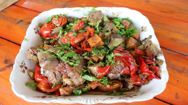 Stewed beef with vegetables in a cast iron pot. Stewed meat.