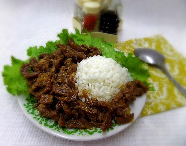 Beef with rice stewed in a cauldron on the stove