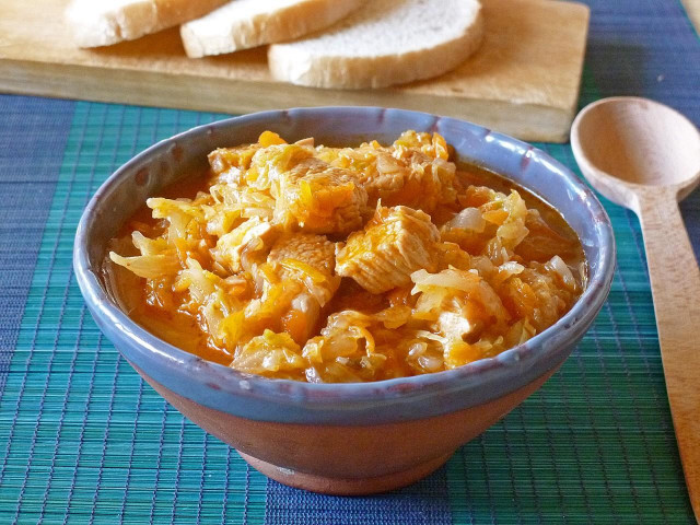 Stewed cabbage with chicken and carrots in a saucepan