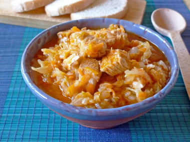 Stewed cabbage with chicken and carrots in a saucepan