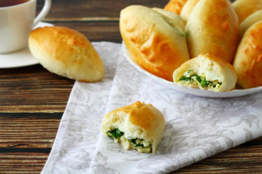 Yeast pies with green onion and egg in the oven
