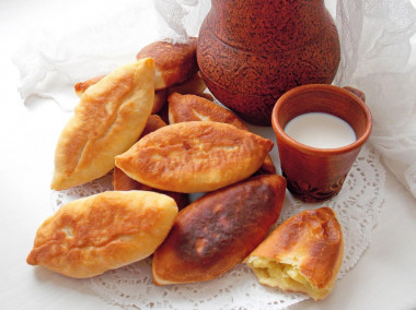 Fried yeast pies in a frying pan