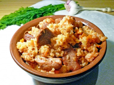 Pilaf with tomato paste and pork in a saucepan on the stove