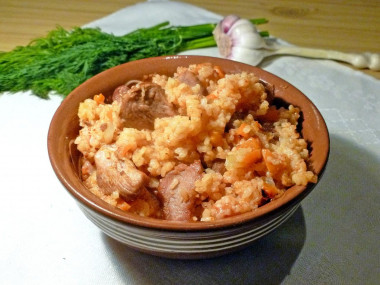 Pilaf with tomato paste and pork in a saucepan on the stove