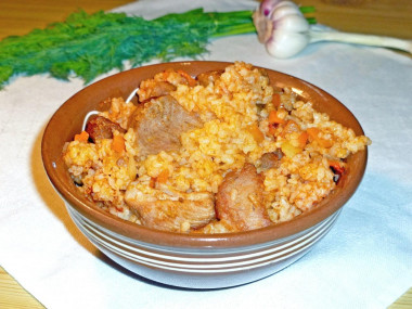 Pilaf with tomato paste and pork in a saucepan on the stove