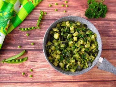 Zucchini with green peas in a frying pan