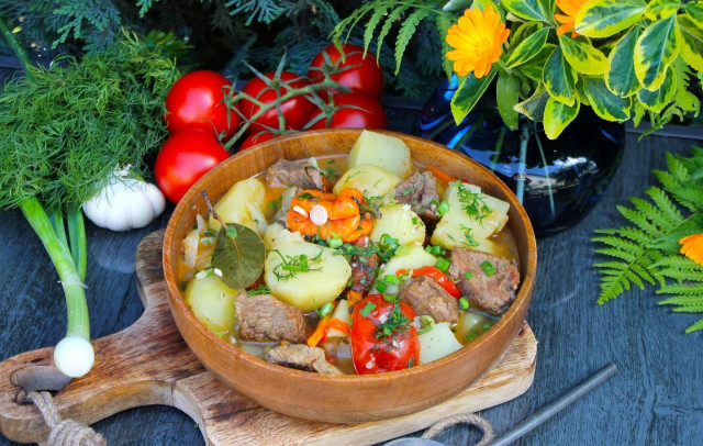 Beef and potatoes stewed in a cauldron over a campfire