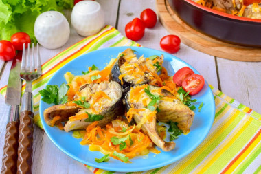 Mackerel with onions and carrots in a frying pan