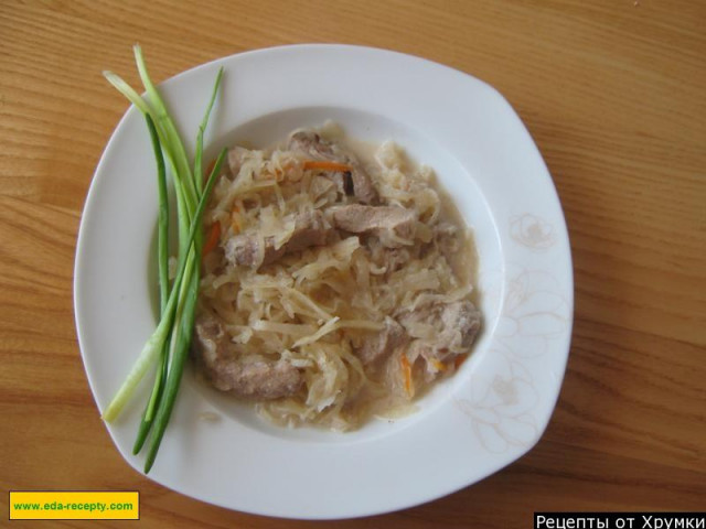Sauerkraut stew with pork and sour cream in a saucepan