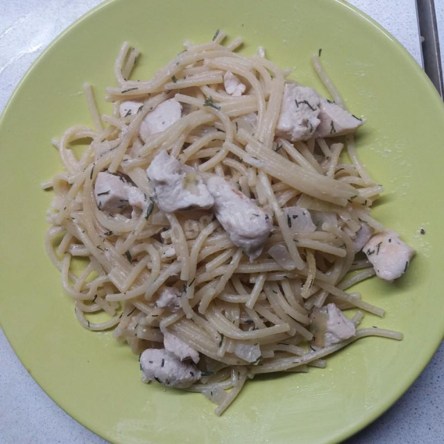 Spaghetti with chicken fillet in sour cream sauce in a slow cooker