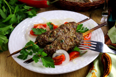 Homemade minced meat kebab in the oven on skewers