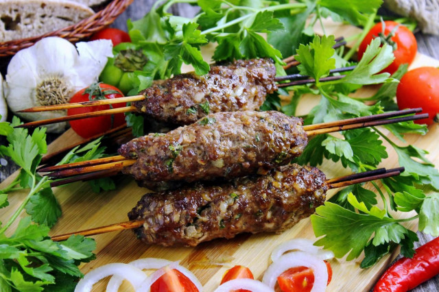 Homemade minced meat kebab in the oven on skewers