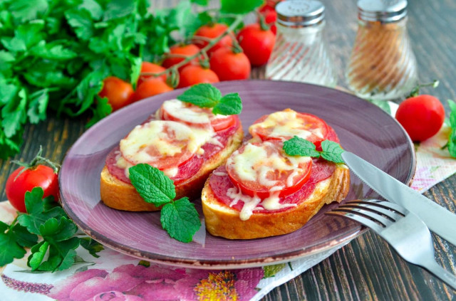 Hot sandwiches with sausage cheese and tomatoes in the oven