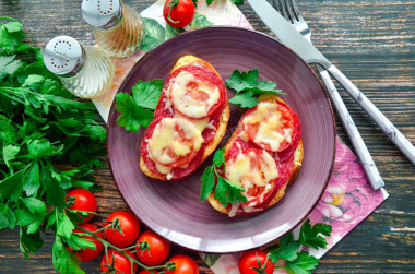 Hot sandwiches with sausage cheese and tomatoes in the oven