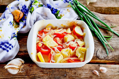 Baked potatoes onions tomatoes in the oven