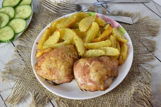 Chicken pieces with crust and potatoes in the oven