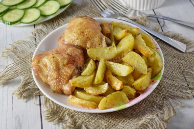 Chicken pieces with crust and potatoes in the oven