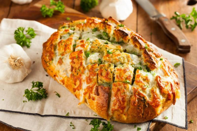 Baked loaf with cheese and garlic in the oven