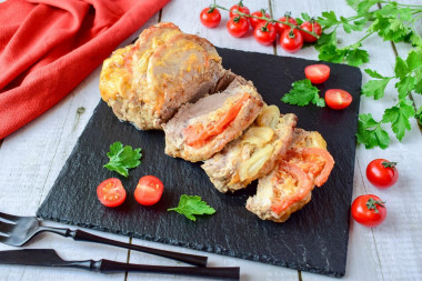 Pork with cheese and tomato in foil in the oven