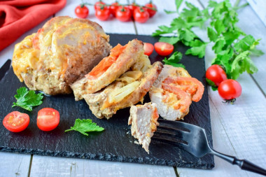 Pork with cheese and tomato in foil in the oven