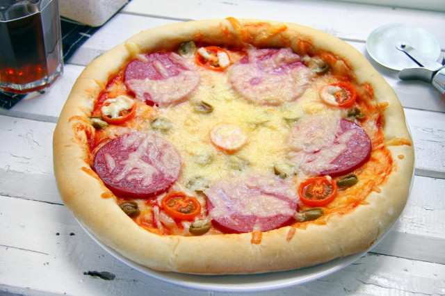 Pizza on thick dough in the oven