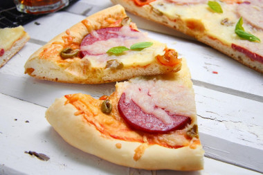 Pizza on thick dough in the oven