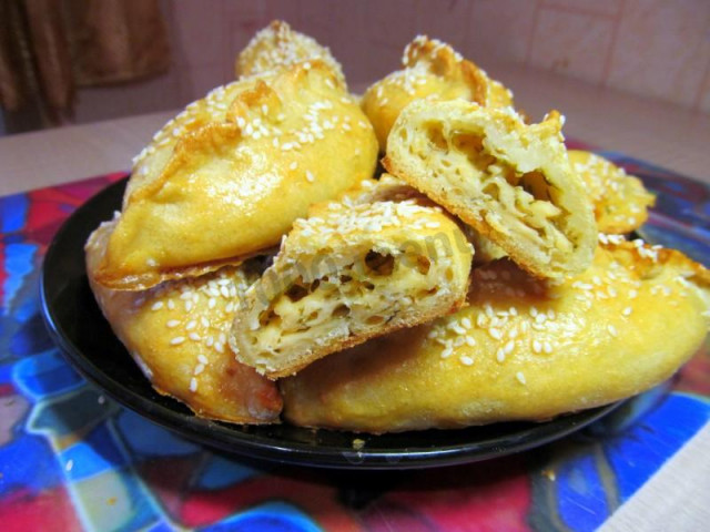 Pies with cheese and greens snacks in the oven