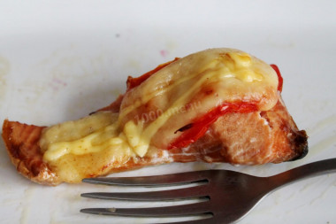 Pink salmon with tomatoes and hard cheese in the oven