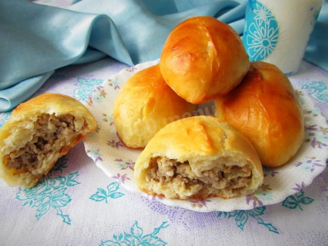 Yeast pies with minced turkey and potatoes in oven