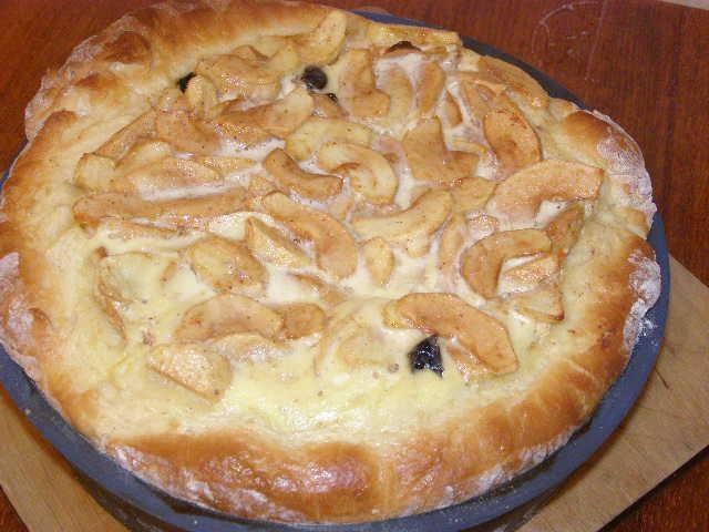 Open yeast pie with apples and raisins in the oven