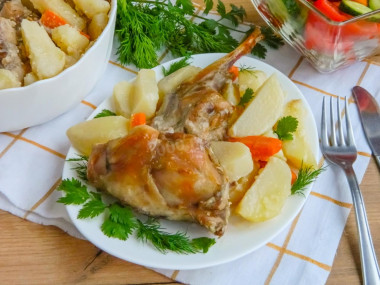 Rabbit baked in sour cream sauce with vegetables in the oven