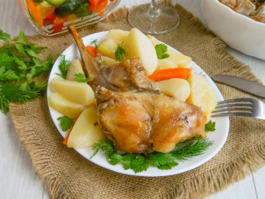 Rabbit baked in sour cream sauce with vegetables in the oven