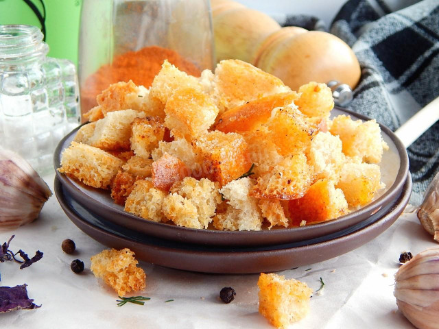 Bread croutons with black pepper and basil in the oven