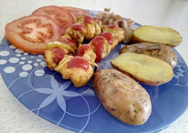 Chicken kebab with baked potatoes in oven