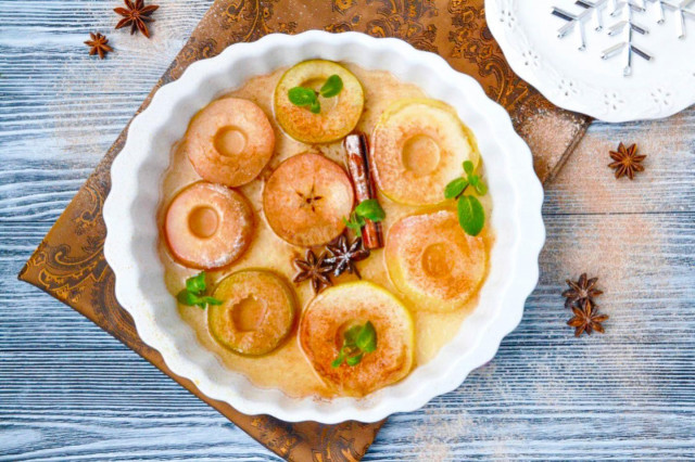 Apples baked in slices in the oven with cinnamon and syrup