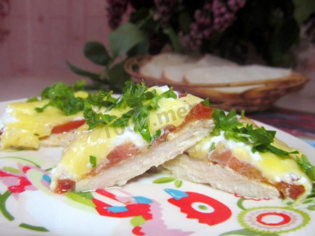 Chicken breast chops with tomatoes and cheese in the oven