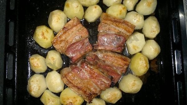 Pork ribs with potatoes and garlic in the oven