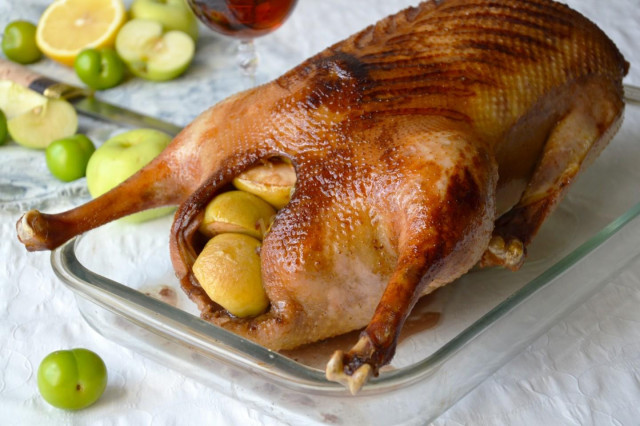 Baked goose with apples and cherry plum in the oven