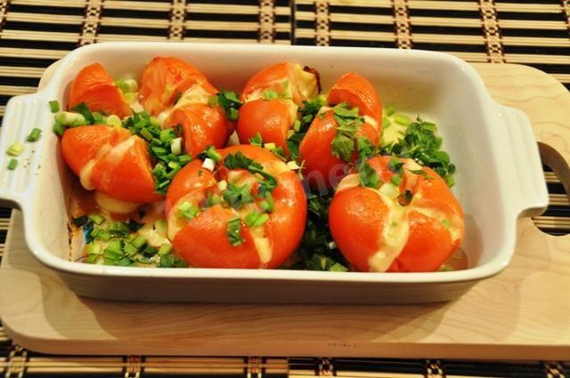 Baked tomatoes with smoked cheese and herbs in the oven
