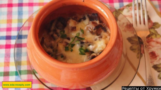 Mushrooms in sour cream in a pot with cheese