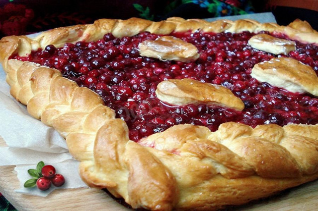 Pie on a baking sheet with cranberries from yeast dough