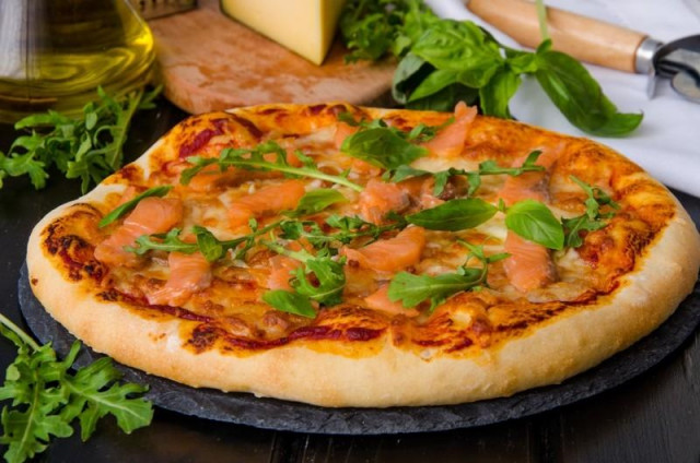 Pizza with red fish on yeast dough
